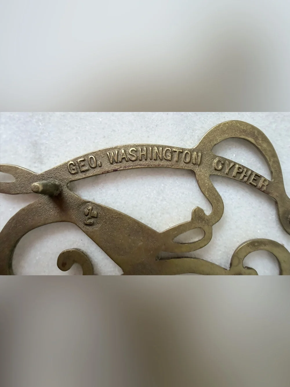 George Washington Cypher solid brass trivet, likely by Virginia Metalcrafters.